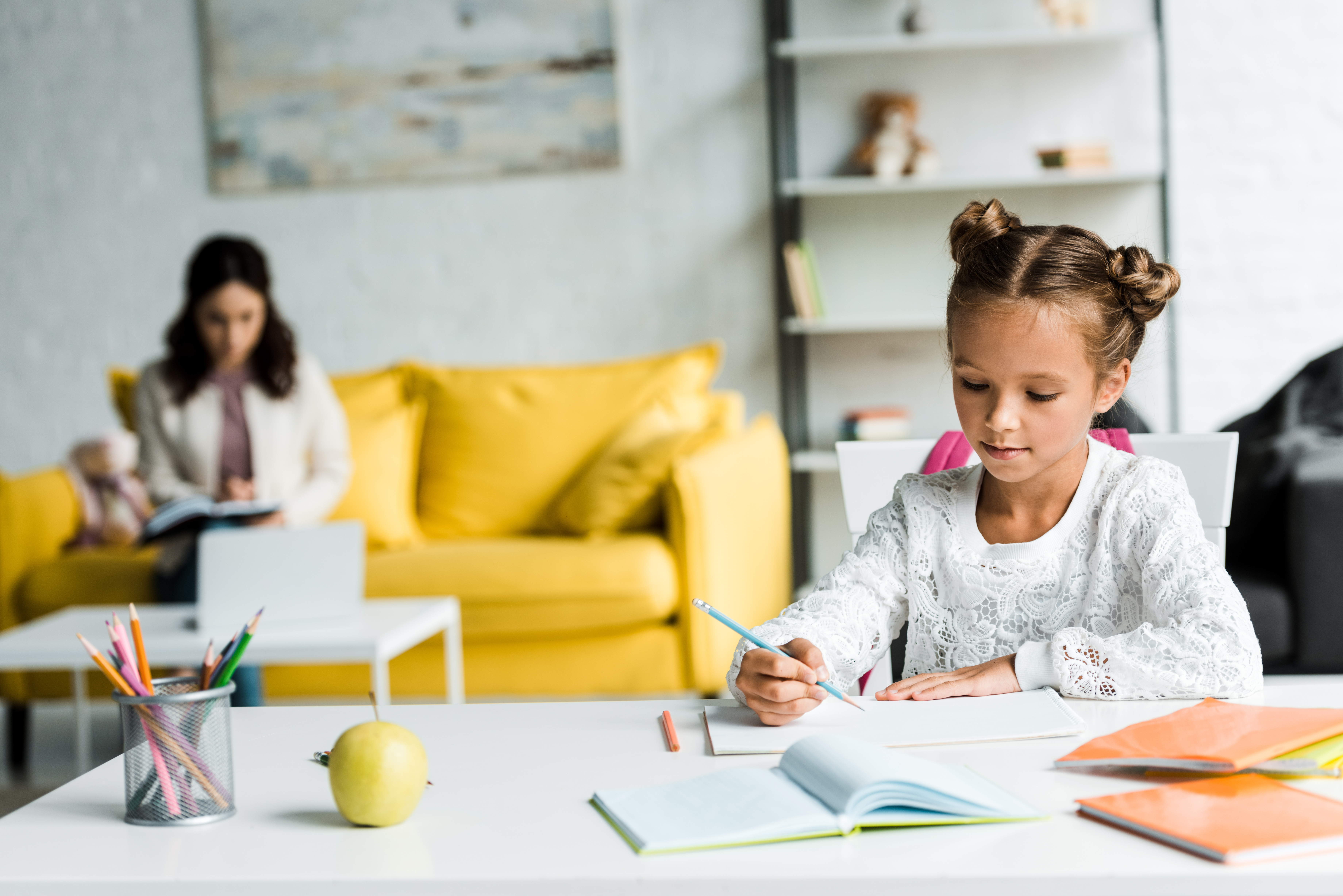 selective-focus-of-cute-kid-drawing-near-books-and-2023-11-27-05-27-38-utc